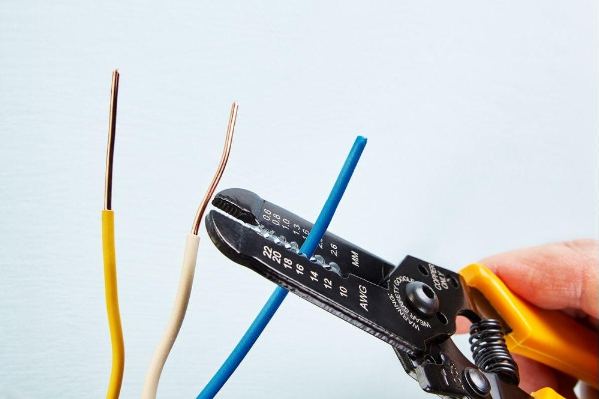 Dùng kìm tuốt lớp vỏ nhựa ở đầu dây điện một đoạn khoảng 2 - 3cm