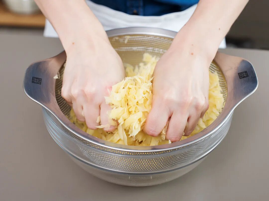 Coarsely grating potatoes. (Source: kitchenstories.com)